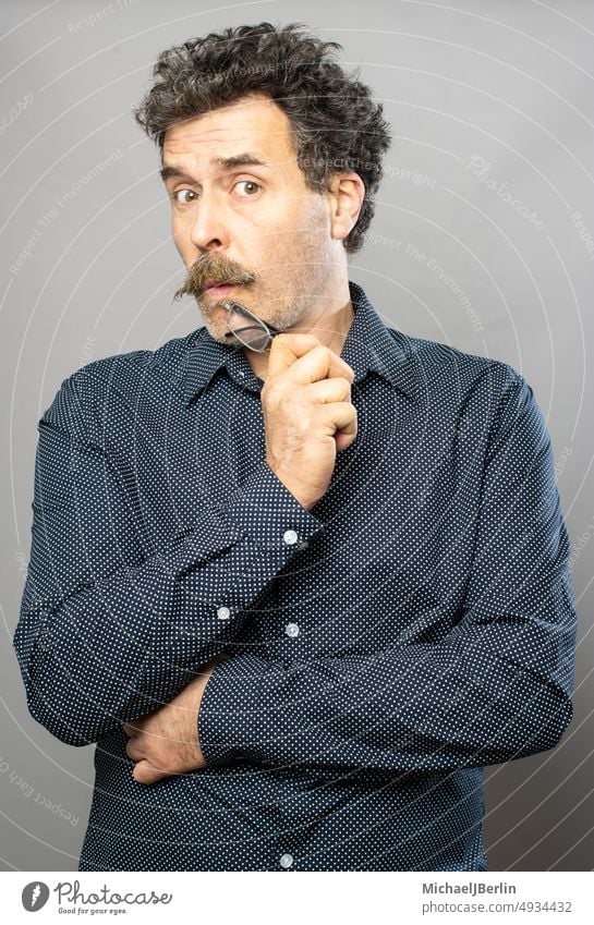 Silly moustache man studio portrait series on grey background 1980's style 50 years old adult aged closeup emotions face fifties look male middle aged people