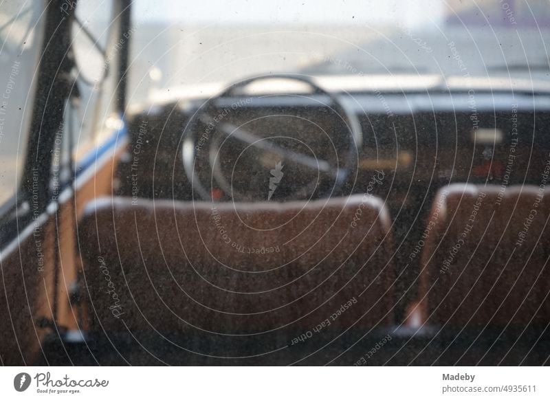 View through the dirty rear window on the interior and dashboard of a German rear engine small car of the sixties at the car museum in Lemgo Hörstmar near Detmold in East Westphalia Lippe