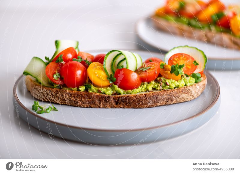 Toast with cherry tomatoes and avocado toast mashed cucucmber bread micro greens lunch breakfast fresh food vegetarian healthy delicious snack gourmet meal