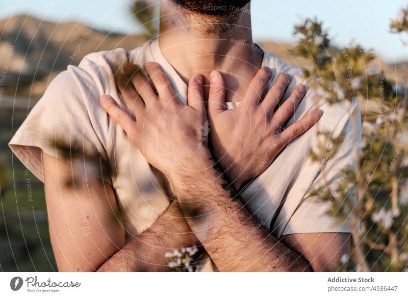 Crop man crossing arms on chest meditate arms crossed countryside calm yoga summer rest weekend nature male plant t shirt zen peaceful tranquil balance daytime