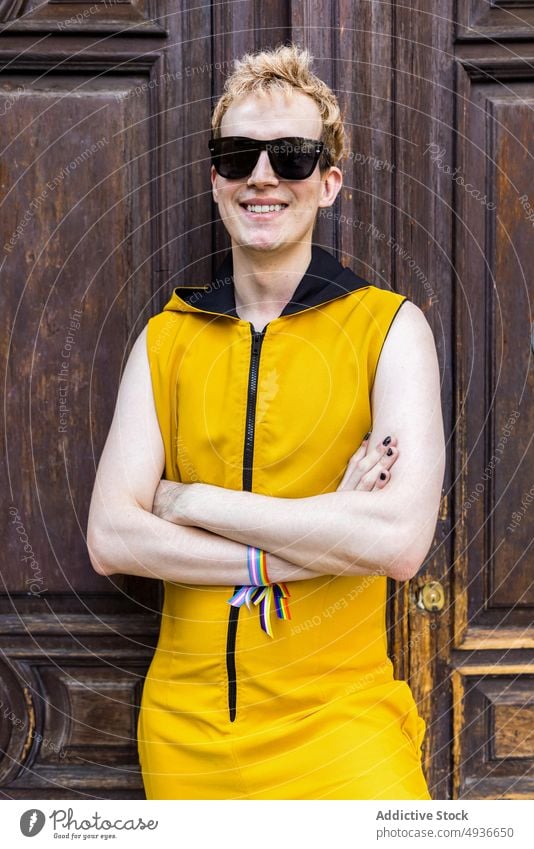 Happy non binary man against old door smile transgender lgbt happy style street portrait male young outfit sunglasses equal bracelet ribbon cheerful lgbtq