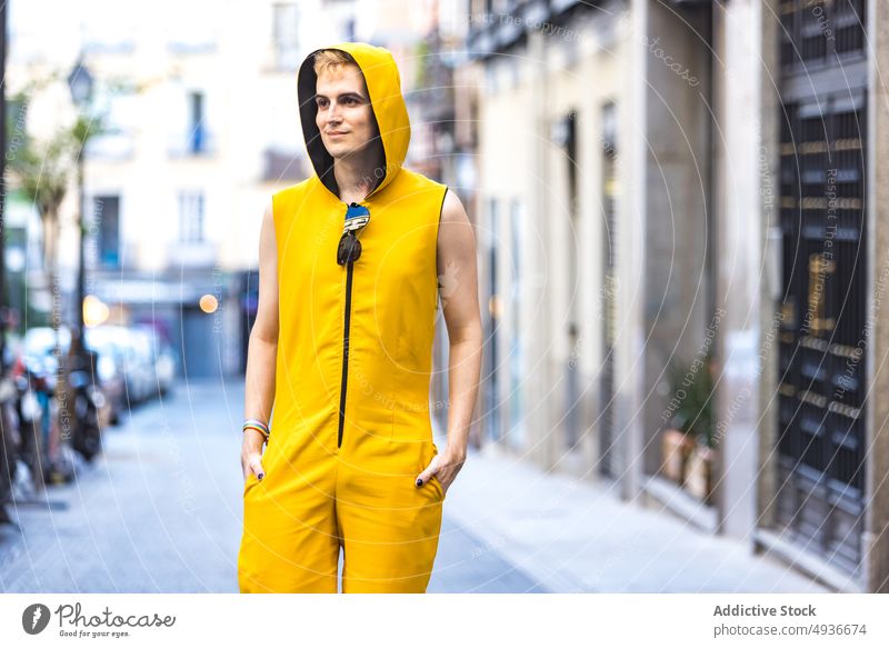 Smiling stylish non binary male on street man style urban pavement delight transgender confident modern lgbt hands in pocket glad young happy smile lgbtq