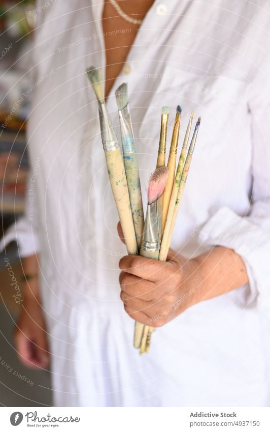 Crop female artist with brushes woman paintbrush show studio creative bunch craft hobby inspiration elderly senior aged work workshop demonstrate job talent set