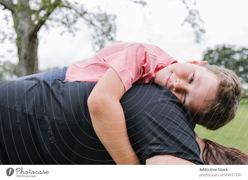 Son lying on mother in park son hug weekend summer together love relationship woman boy motherhood child little childhood kid season mom rest relax parent