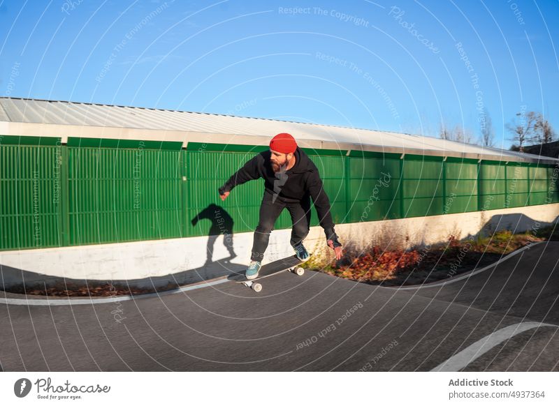 Man riding skateboard on pump track man skate park ride skater hipster hobby activity male energy motion cool beard recreation extreme guy balance practice