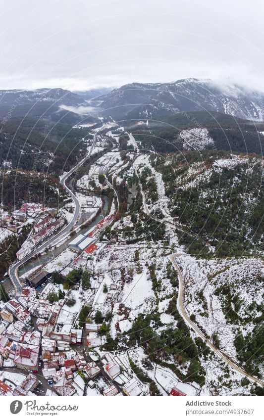 Picturesque mountainous landscape with snowy slopes and narrow river winter road valley ridge fog highland picturesque scenic range scenery peaceful cold mist