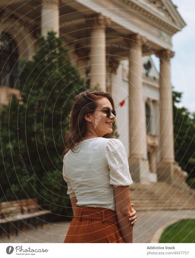 Calm young woman sightseeing in old city district trip tourist architecture building travel facade traveler ancient exterior female brunette casual vacation