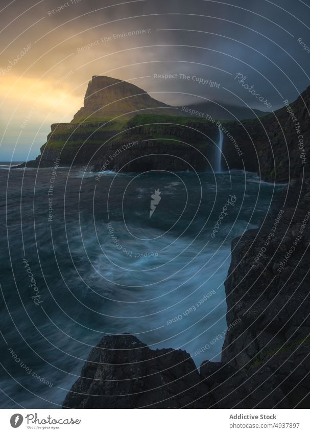 Stormy sea and cliffs at sunrise wave storm rock energy splash cloudy sky faroe islands morning sundown sunset weather water coast ocean shore dawn seascape