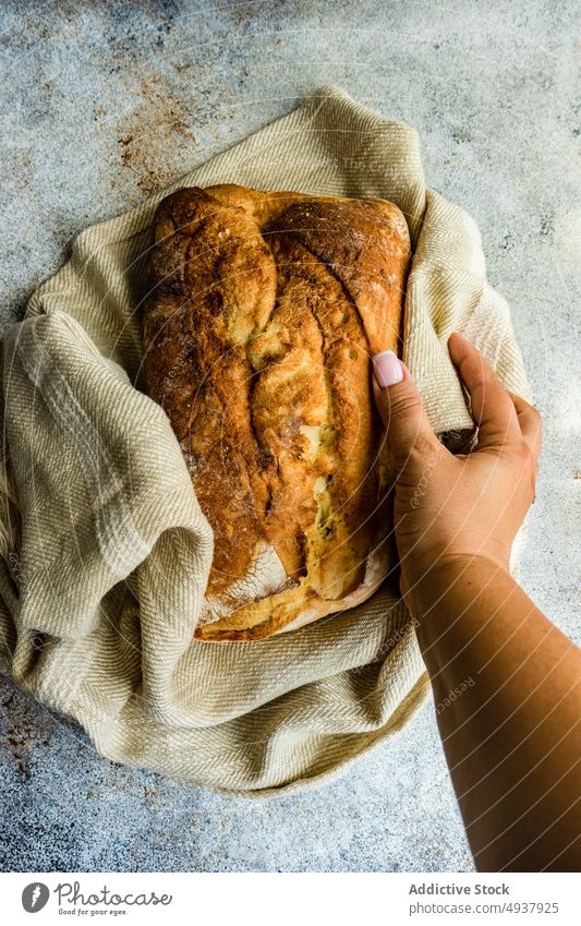 Fresh baked healthy brad on the towel Whole grain background baguette baking bread cook cooking food french fresh gourmet hand hold homemade overhead table