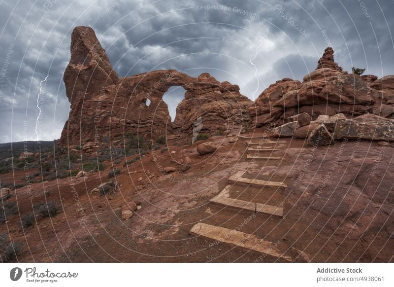 Steps leading to natural arch during lightning storm step thunderstorm cloudy sky stone formation landmark arches national park turret arch moab utah usa