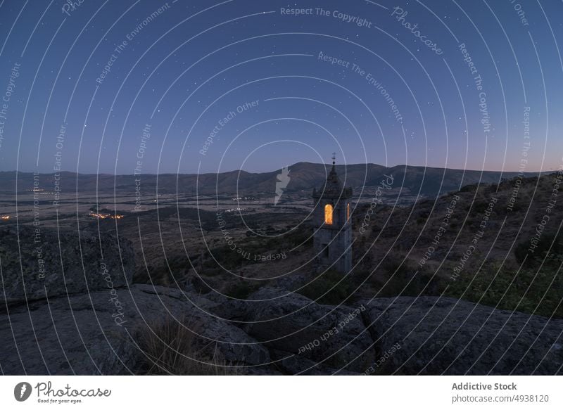 Illuminated bell tower on hill monastery night sky starry countryside illuminate old avila spain ruin remain architecture dark historic evening landmark worship