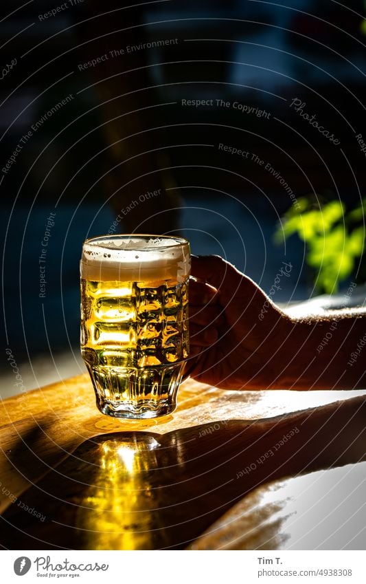 a pilsner beer glass in one hand Beer Glass Light Alcoholic drinks Beer garden Prenzlauer Berg Berlin Deserted Exterior shot Colour photo Beverage Town