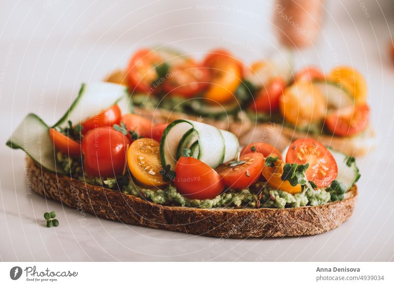 Toast with cherry tomatoes and avocado toast mashed cucucmber bread micro greens lunch breakfast fresh food vegetarian healthy delicious snack gourmet meal