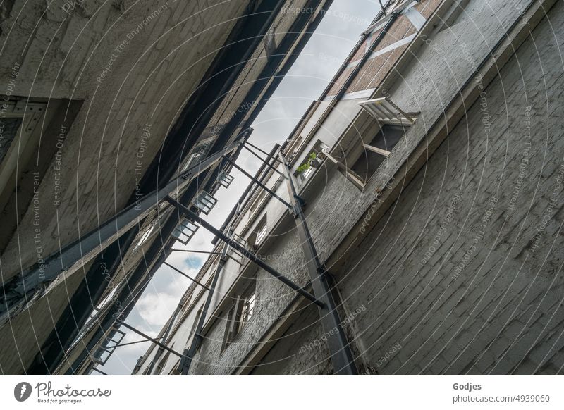 View upwards from a corridor between two houses secured by steel struts Passage Hamburg Channel Alley Window Steel Steel carrier Brick White Architecture