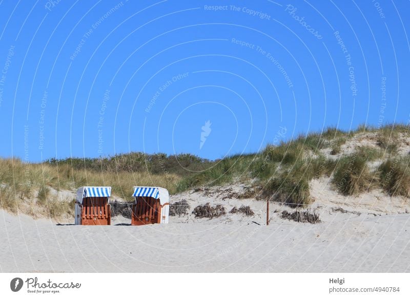 two locked beach chairs stand in the sand in front of the dunes when the weather is nice Beach chair duene Sand Summer Beautiful weather Helgoland sunshine