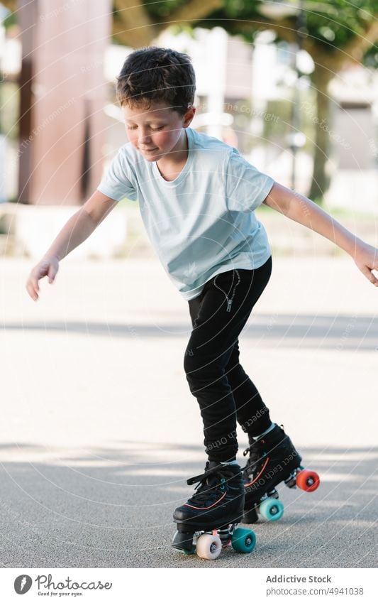 Boy riding roller skates on street boy ride summer weekend activity hobby daytime urban kid pastime casual childhood free time practice lifestyle season path