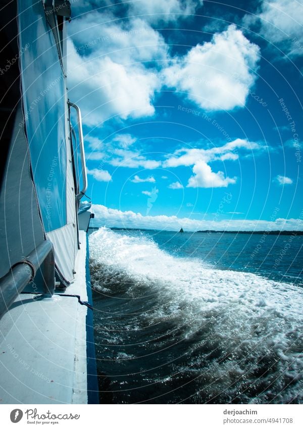 The boat is moving fast on the starboard side through the waves. Land is in sight in the background on the horizon. Boating trip Water Navigation Exterior shot