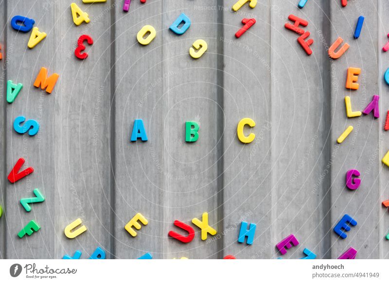 The letters abc on a tin wall in gray surrounded by numbers and letters alphabet back to school beginning blackboard childhood college colourful concept