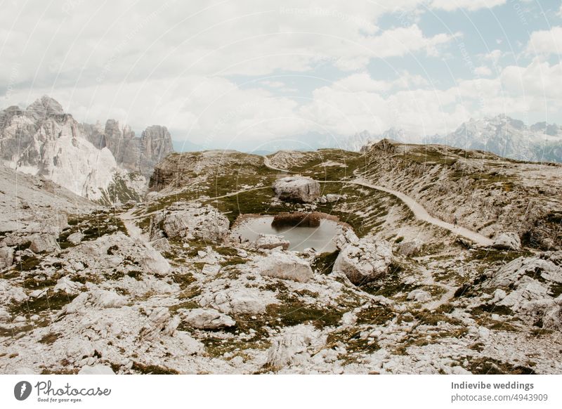 A rocky scenery in the Alps in Europe. Rock stone landscape in the mountains. Nobody on the image. Natural pond, blue sky, clouds in the sky. alps beautiful