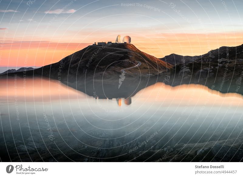 Reflections of an abandoned military base at sunset, with beautiful orange clouds in the background, Northern Italy abandoned building abandoned ruins alps