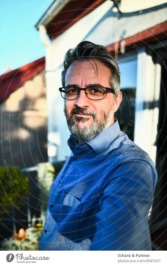 Man with beard and glasses looks confident Selfie portrait Shirt Facial hair Eyeglasses Earnest grin hard light Light Shadow Exterior shot Self portrait