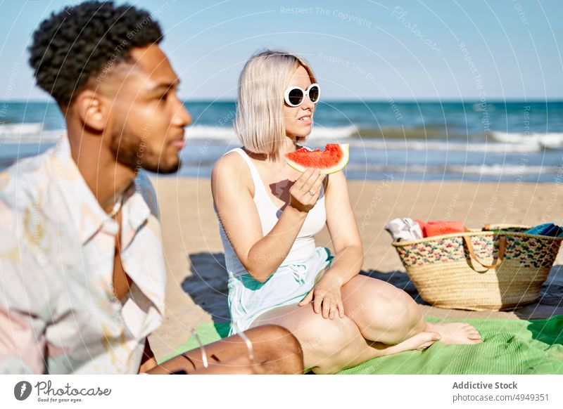 Diverse friends eating fruits and listening to guitarist play beach smile sea summer men women weekend picnic happy coast melody holiday music song together