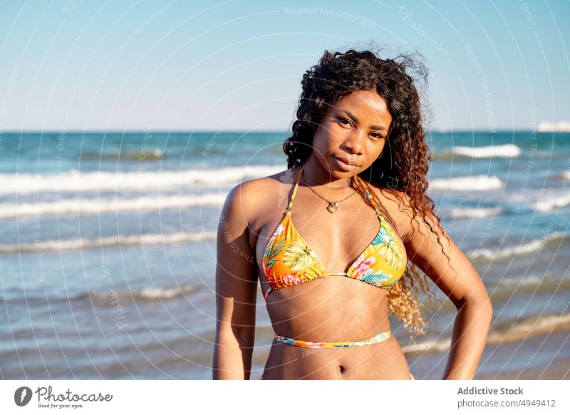 Cheerful black woman near sea beach smile tourist weekend happy bikini summer vacation female wave resort african american ethnic holiday optimist glad tourism