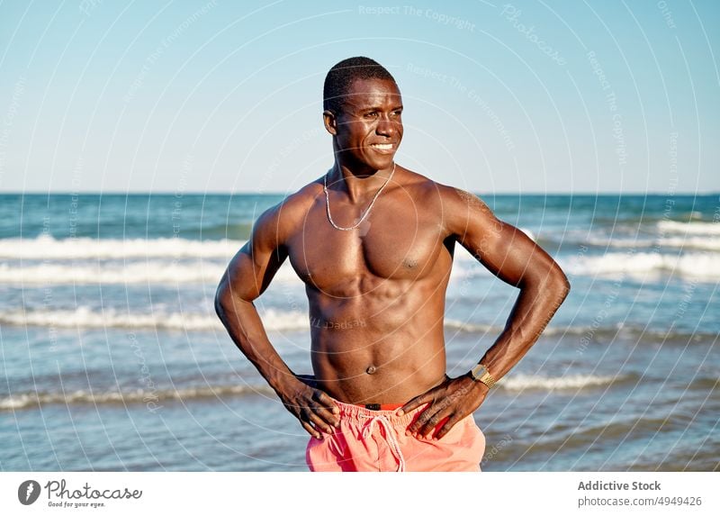 Happy black male tourist standing near sea man beach summer weekend resort vacation smile holiday coast shore glad tourism activity water happy african american