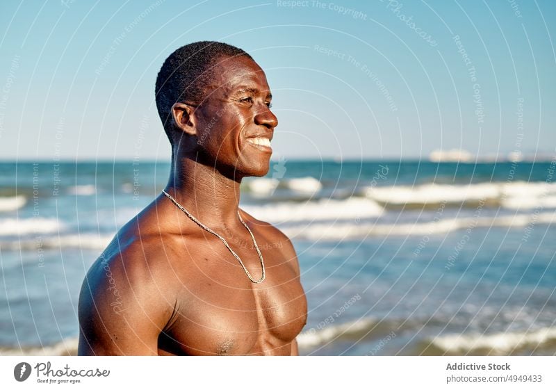 Cheerful black male smiling near sea man smile beach happy weekend summer blue sky cheerful water african american ethnic friendly carefree positive holiday