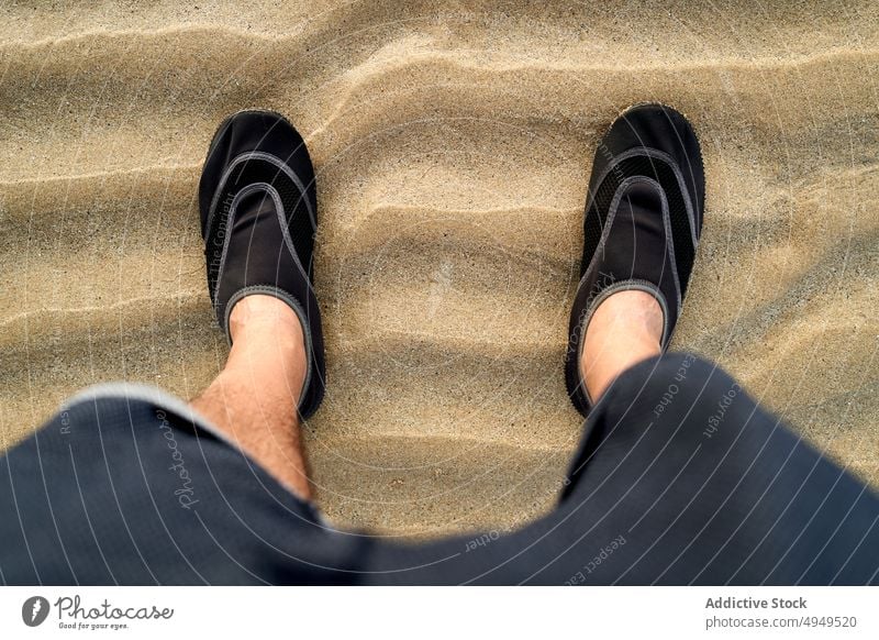 Crop man standing on sand beach ripple summer weekend shoe vacation seashore dry male wave resort coast footwear seaside daytime casual recreation season alone