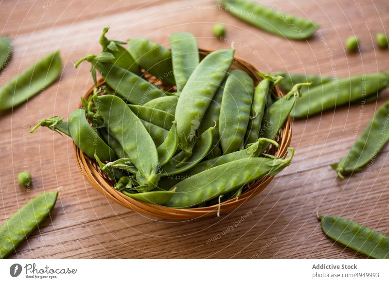 Wicker bowl with snow peas table ripe fresh vegan diet wicker many raw product organic vitamin healthy food veggie vegetarian wooden uncooked kitchen domestic