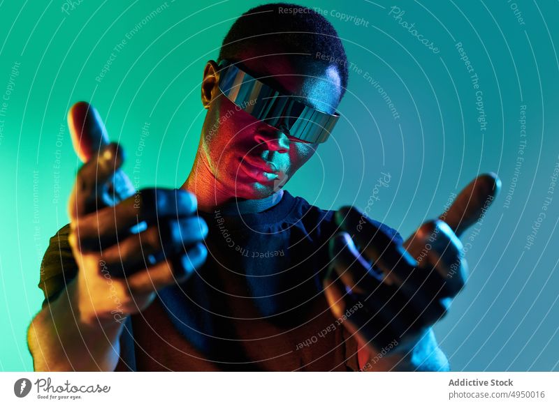 Confident black man in futuristic headset reaching out hand to camera reach out virtual reality digital serious vr cyberspace portrait innovation experience