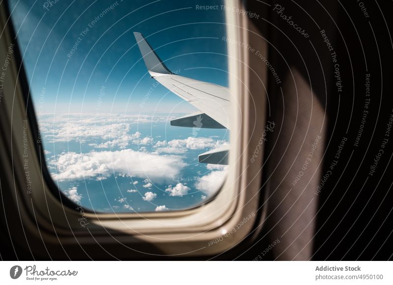 Plane wing in cloudy sky window plane blue sky trip flight aviation fly travel jet transport modern aeroplane airline contemporary airplane altitude motion