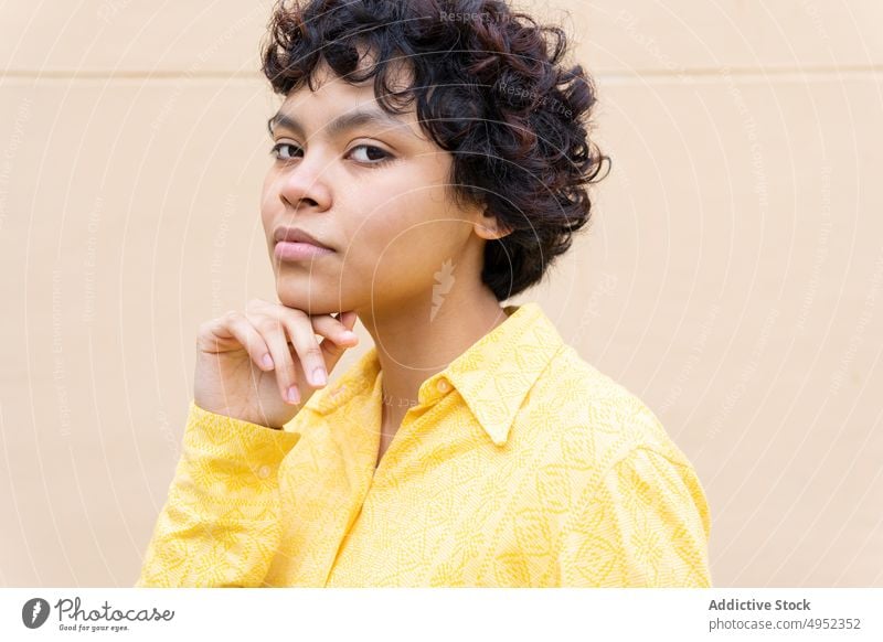 Tender young ethnic woman in vivid shirt calm portrait gentle pure teen appearance style tender yellow street pensive ponder feminine touch chin dreamy peaceful