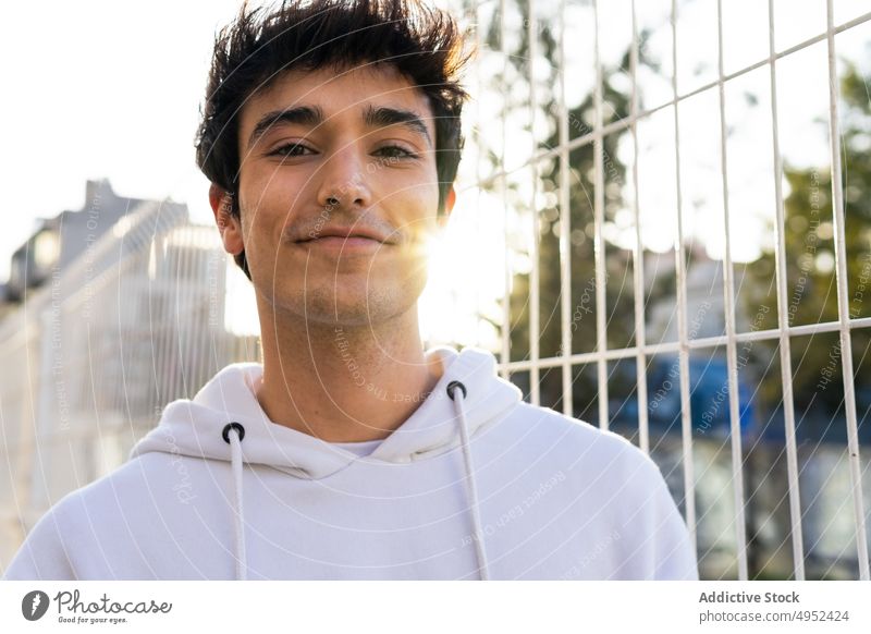 Stylish man standing near metal grid in city style fence trendy outfit urban content male young street confident personality handsome hipster cool appearance