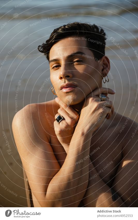 Shirtless ethnic man sitting on chair near sea beach style rest shirtless model wave wet male young water relax coast shore summer ocean energy vacation holiday