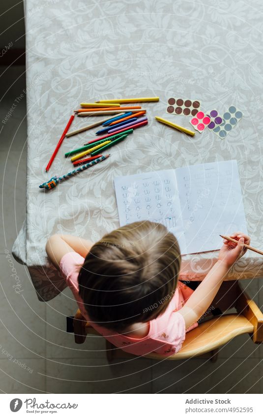 Cute Little Girl Doing Homework top view child education paper writing girl faceless homework sit indoors alone attention bedroom book casual caucasian daughter