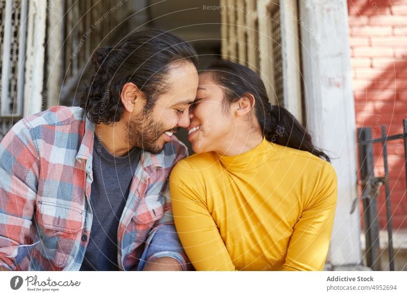 Smiling Mexican couple spending time on staircase on sunny day relationship love romantic cheerful fondness soulmate portrait urban ethnic mexican content