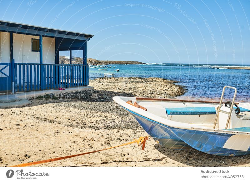 Motor boat on sea coast against house motorboat ocean nature seascape landscape architecture moor nautical blue sky transport veranda fence mount highland