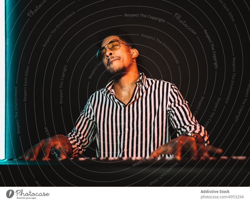 Black man playing synthesizer in studio musician audio hobby record skill acoustic male piano electric perform sound melody player tune instrument rehearsal