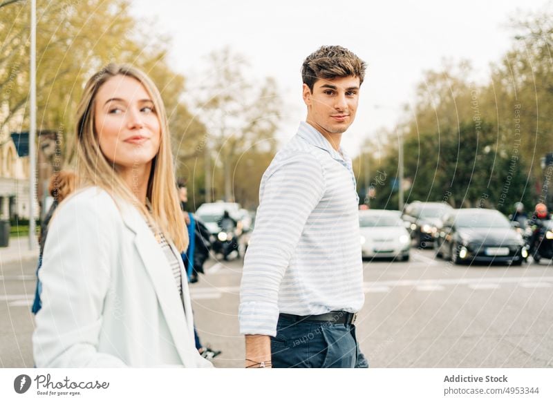 Happy couple crossing road in city holding hands walk stroll love together relationship street urban style trendy content smile happy girlfriend boyfriend