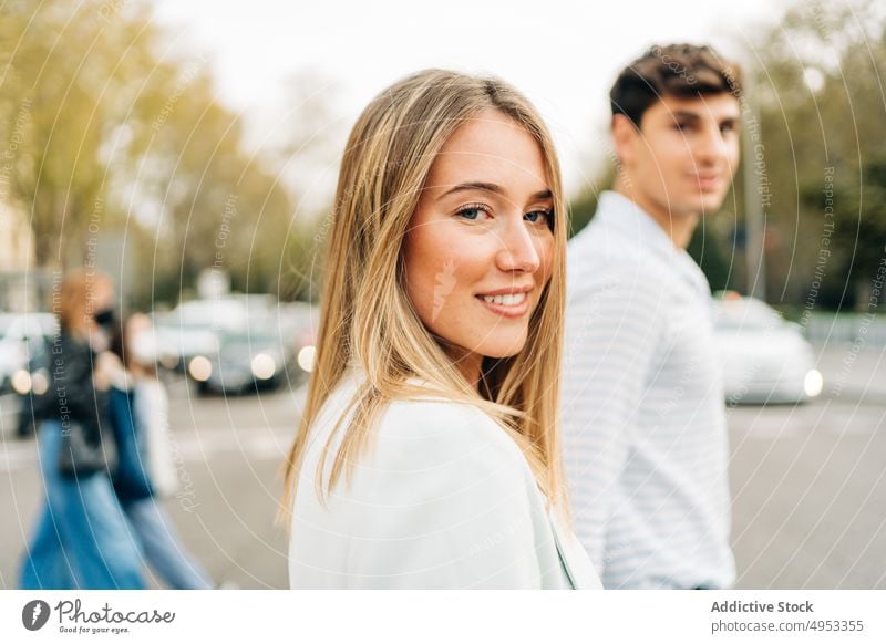 Cheerful couple crossing road in city holding hands walk stroll love together relationship street urban style trendy content smile happy girlfriend boyfriend