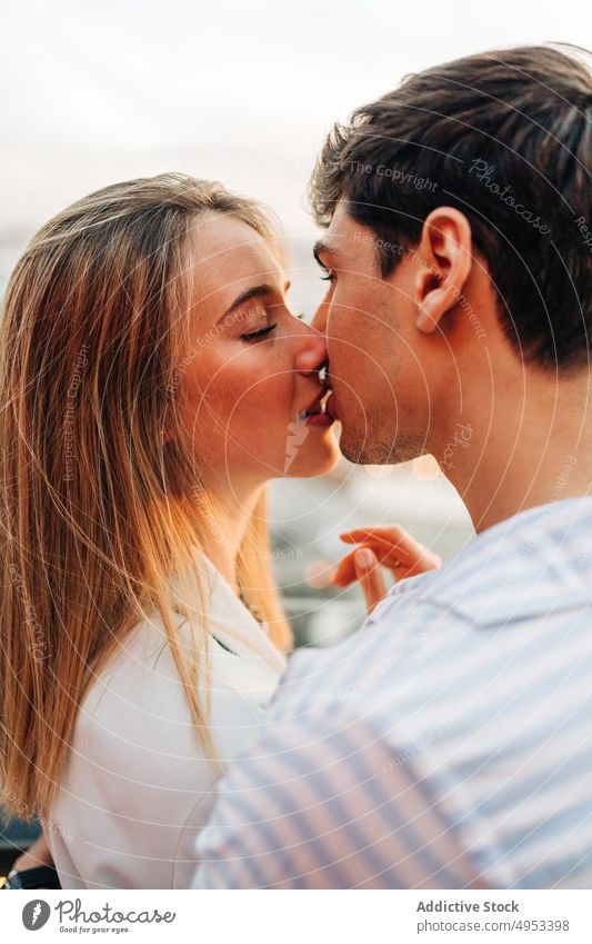 Loving couple kissing in rooftop cafe date romantic evening restaurant tender love serene hug embrace together relationship affection bonding romance tranquil