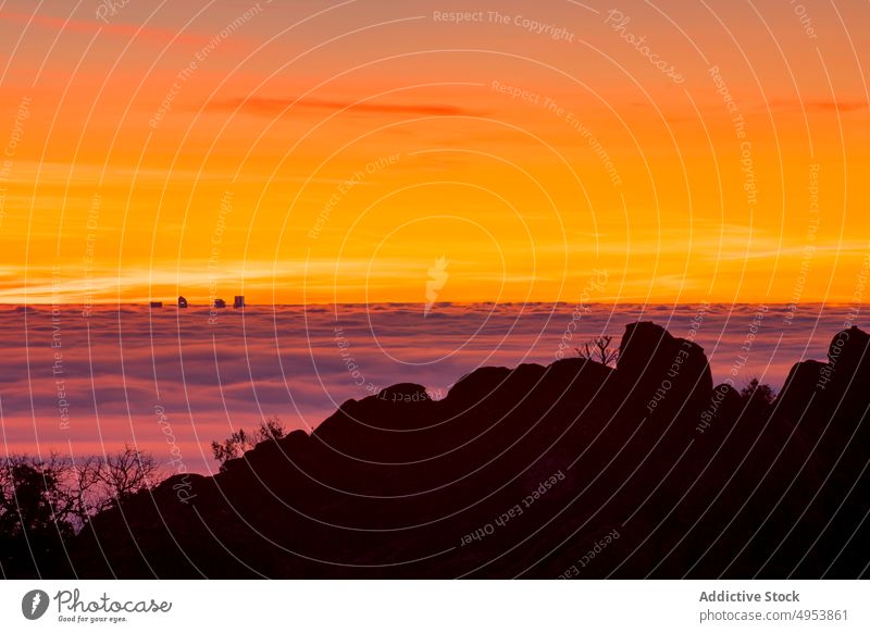 Silhouette of modern buildings among clouds at sunrise silhouette sunset rock mountain sky high nature active extreme fog cliff top peak male challenge free