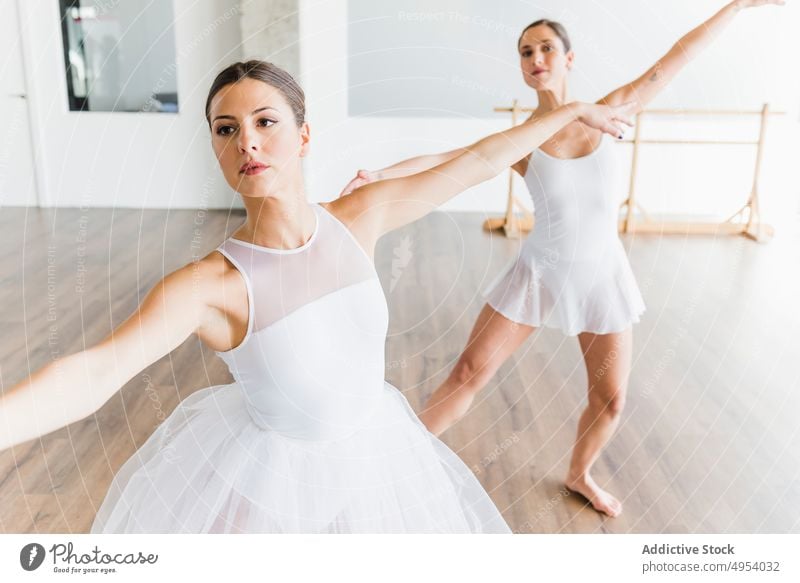 Two synchronized ballerinas dancing woman studio romantic art dance professional femininity ballet performance grace position practice pose flexibility female