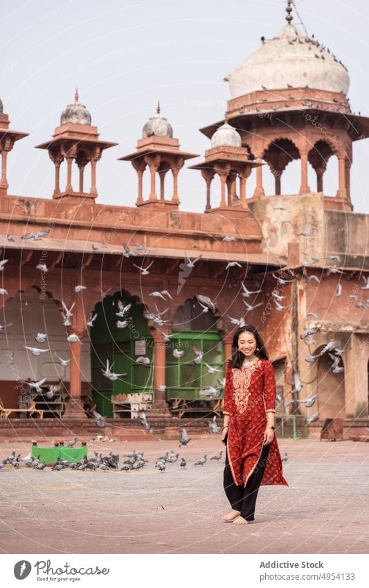 Ethnic woman near pigeons outside Grand Mosque run street old mosque fun jama masjid agra india uttar pradesh barefoot flock aged bird animal building ancient