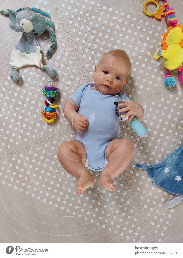 Curious beautiful baby boy in blue body lying on playing mat, looking in the camera Boy (child) Baby adorable newborn Newborn kid Infancy Child cutie cute