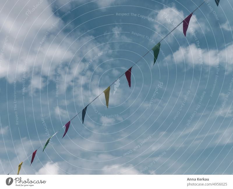 A colorful pennant chain waves in the blue sky flag in the wind motley variegated Blow Sky Decoration Adorned Event Street party Festival Village fair