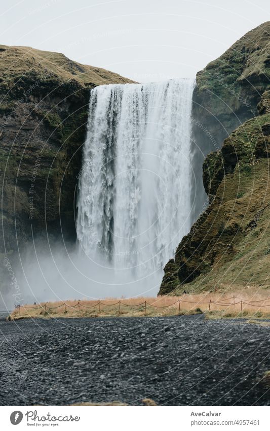 Skógafoss waterfall in Iceland during a moody day. Travel on van concept, road trip style. Visit Iceland and north countries concept.Copy space image skófagoss