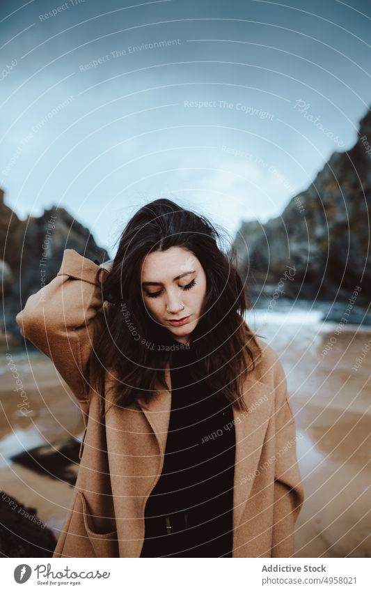 Stylish female on windy day near sea woman shore style young lifestyle leisure rest relax coast trendy harmony calm tranquil serene peaceful weather casual